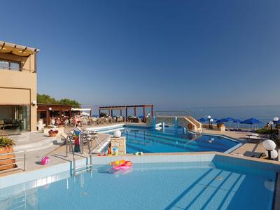 Moderner Poolbereich mit Sonnenterrasse, Meerblick und klar blauem Himmel