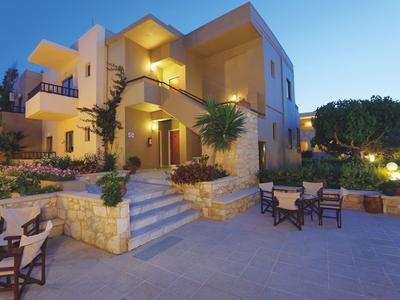 Modernes Hotelgebäude mit Terrasse und Außenmöbeln bei Dämmerung