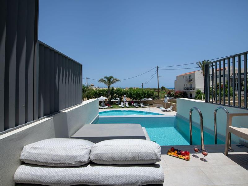 Modern pool area with lounge cushions and clear blue water under a clear sky