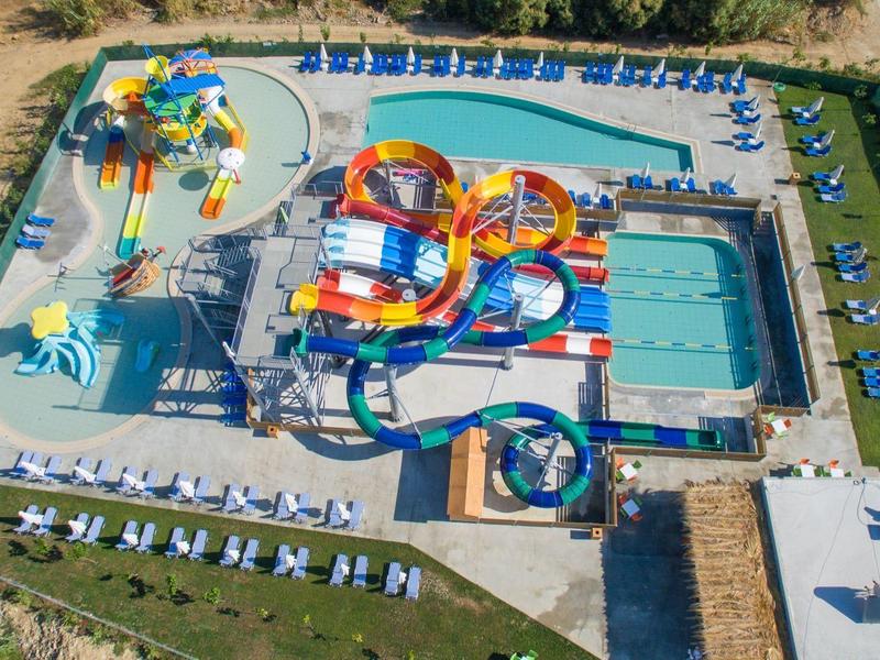 Aerial view of a water park with multiple colorful water slides and a swimming pool.