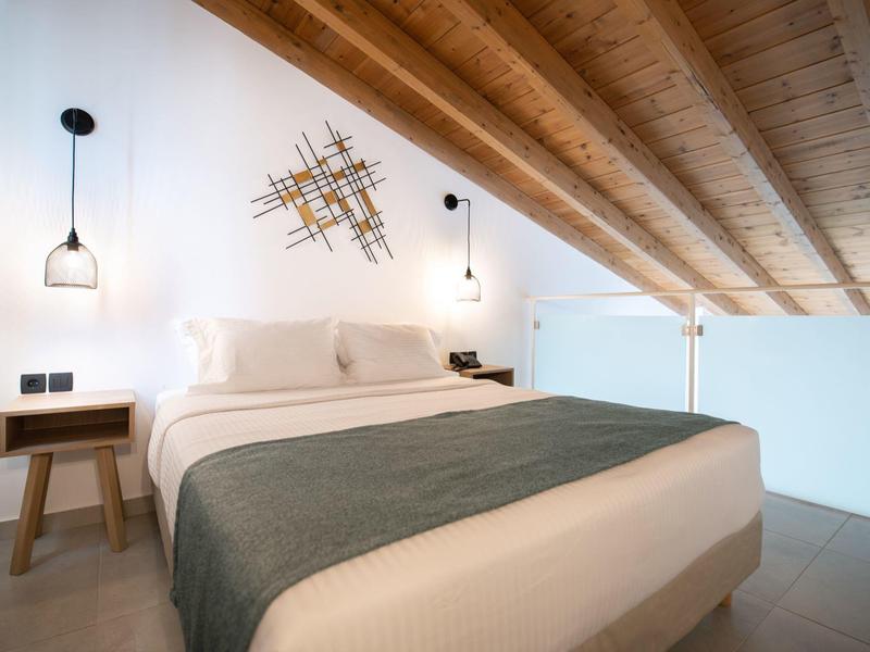 Modern bedroom with wooden ceiling, double bed, nightstands, and minimalist wall decoration.