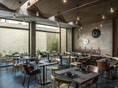 Modern eingerichteter Speiseraum mit großen Fenstern und minimalistischer Dekoration.