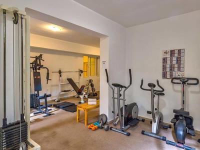 Kleiner Fitnessraum mit verschiedenen Trainingsgeräten und neutraler Einrichtung.