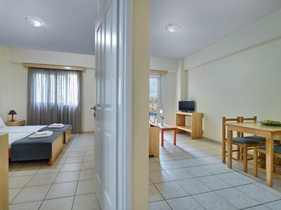 Světý byt s obývacím pokojem, jídelnou a televizí, oddělený zdí.