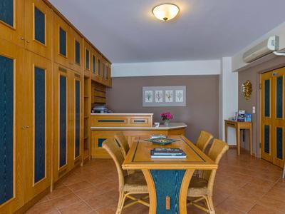 Jídelní kout se dřevěným stolem a šesti židlemi v světlé, moderní místnosti.