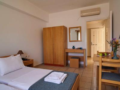 Hotelový pokoj s jednolůžkem, dřevěným nábytkem, psacím stolem a klimatizací.