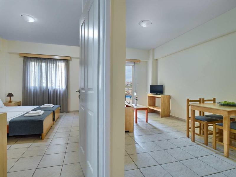 Světý byt s obývacím pokojem, jídelnou a televizí, oddělený zdí.