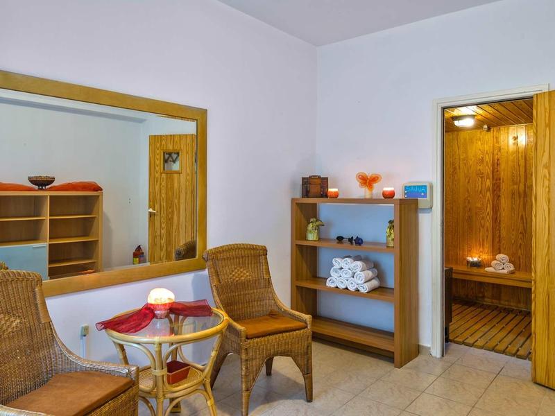 Pohodlná wellness zóna se dvěma židlemi, stolem a výhledem do sauny