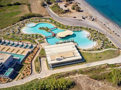 Luftaufnahme eines Hotels mit einer großen, geschwungenen Poolanlage nahe dem Strand.