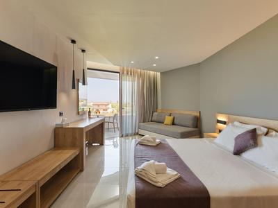 Modernes Hotelzimmer mit Doppelbett, Balkon und Stadtblick, hellem Holzmöbeln und neutralen Farben.