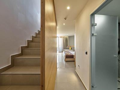 Gang met trap aan de linkerkant, slaapkamer recht vooruit en badkamer met glazen deur aan de rechterkant.