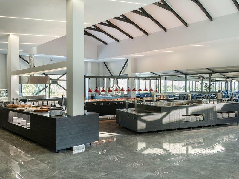 Modern ingerichte, lichte hotellobby met zitplaatsen en grote ramen.