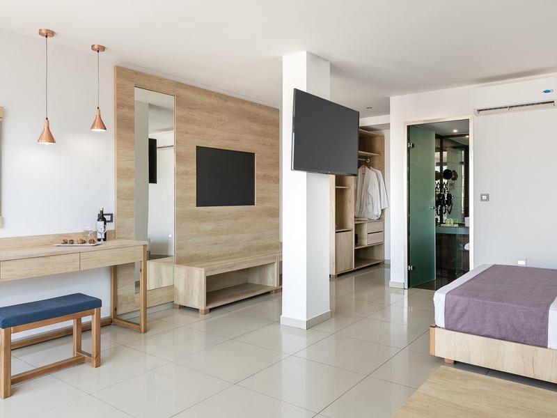 Modern hotelkamer met houten accenten, flatscreen-tv en raam met veel daglicht.