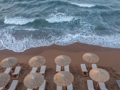 Aerial view of a sandy beach with umbrellas and calm sea waves