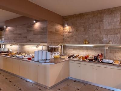 Buffet area in a hotel with various dishes and drinks on light countertops.