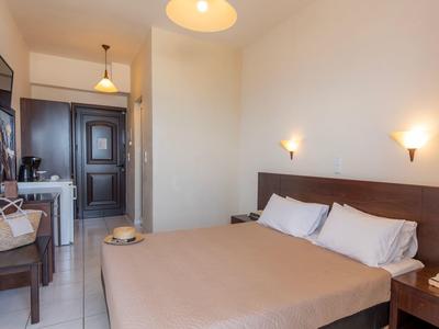 Bright hotel room with double bed, desk, and modern furnishings.