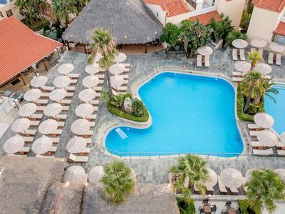 Luftaufnahme eines Hotels mit blauem Pool und Sonnenschirmen in tropischem Ambiente.