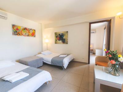 Lichte hotelkamer met twee eenpersoonsbedden, tafel met bloemen en moderne decoratieve kunst aan de muren.