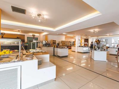 Lichte, moderne ontbijtruimte met buffetten en zitplaatsen in een hotel.