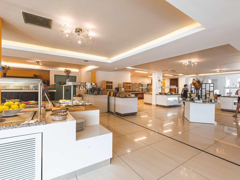 Lichte, moderne ontbijtruimte met buffetten en zitplaatsen in een hotel.