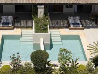 Piscine d'hôtel moderne avec transats et plantes, atmosphère paisible
