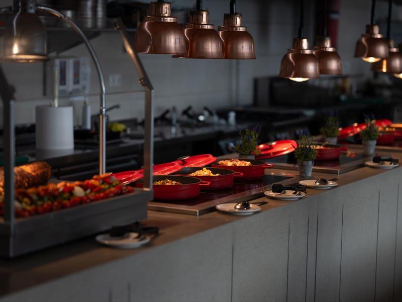 Buffet avec différents plats chauds dans un cadre de restaurant moderne.