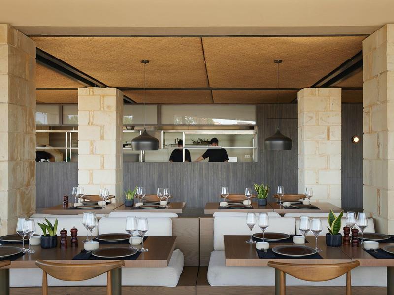 Restaurant moderne avec tables en bois, chaises blanches et élégante décoration de table.