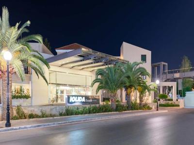 Modern hotel building with palm trees and lighting at night