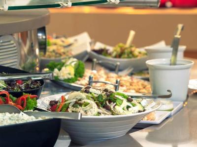 Buffet with various salads and side dishes in bowls and dishes.