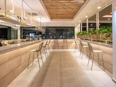 Modern hotel bar area with tall chairs and spacious layout.