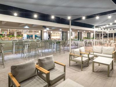 Modern hotel outdoor area with cozy seating and a well-lit bar space.