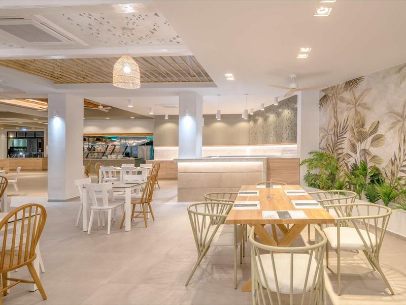 Bright, modern restaurant with stylish tables, chairs, and plant-based decorations.