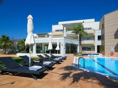 Moderner Hotelpool mit Liegen und Sonnenschirmen bei klarem Himmel.