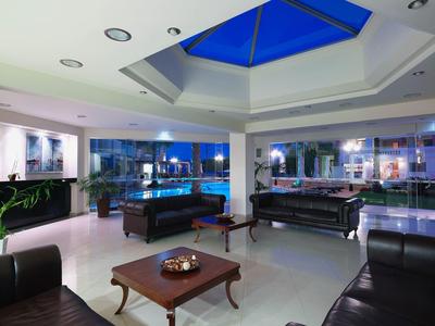 Heldere hotel lobby met leren banken, tafels en groot dakraam