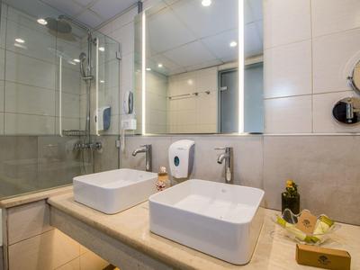 Moderní koupelna s dvojitými umyvadly, velkým zrcadlem a sprchovým koutem se skleněnými dveřmi