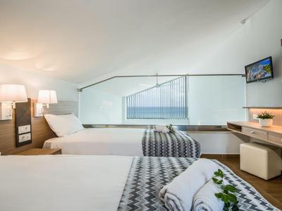 Nowoczesny pokój hotelowy z dwoma łóżkami, stylowym oświetleniem i widokiem na schody.