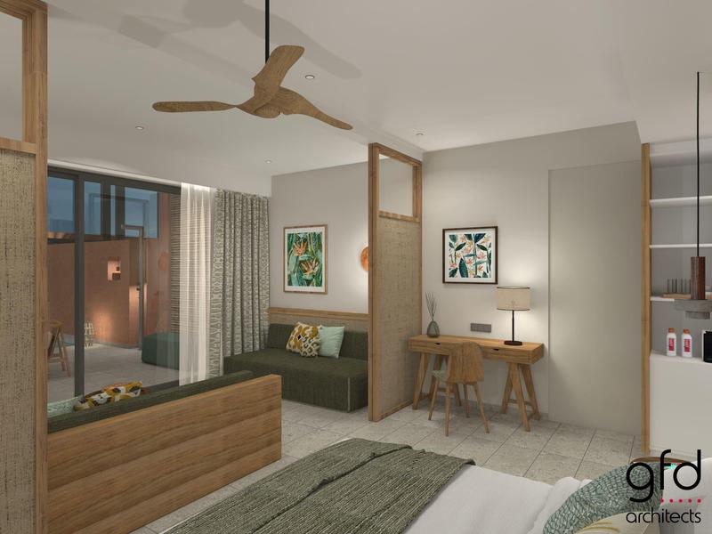 Moderní hotelový pokoj s postelí, pohovkou, psacím stolem a stropním ventilátorem v neutrálních tónech.