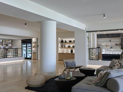 Moderner, offener Hotel-Loungebereich mit Sitzgelegenheiten und Verkaufstresen.