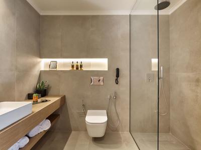 Modernes Badezimmer mit hängendem WC, großer Duschkabine und Holzregal mit Handtüchern.