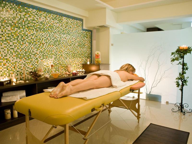 Vrouw ligt op massagetafel in rustige spa-ruimte met sfeerverlichting.