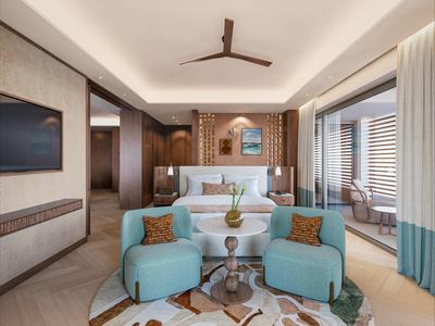 Moderní hotelový pokoj s manželskou postelí, dvěma modrými křesly a balkonem s výhledem na moře.