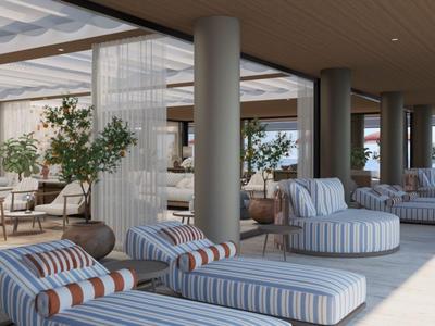 Lounge-Bereich mit gestreiften Polstermöbeln und großen Fenstern in einem modernen Hotel.