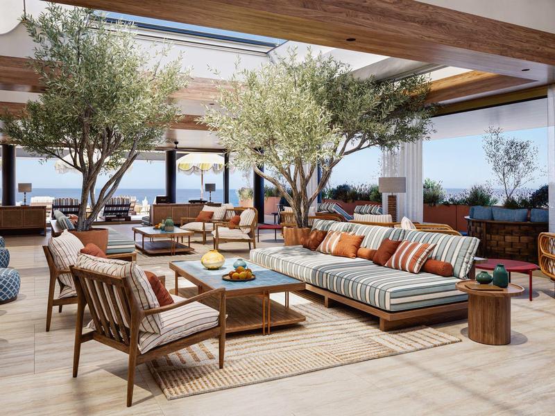 Moderní venkovní hotelový salon s pohodlnými pohovkami, židlemi a stromy pod dřevěnými trámy.