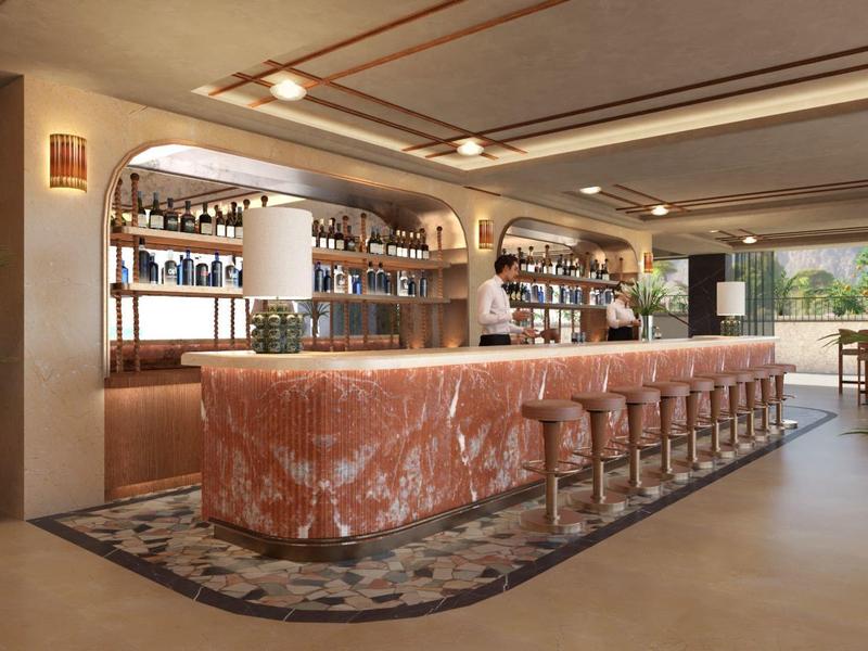 Elegantní hotelový bar s dlouhým mramorovým pultem a stoličkami v teplé atmosféře.