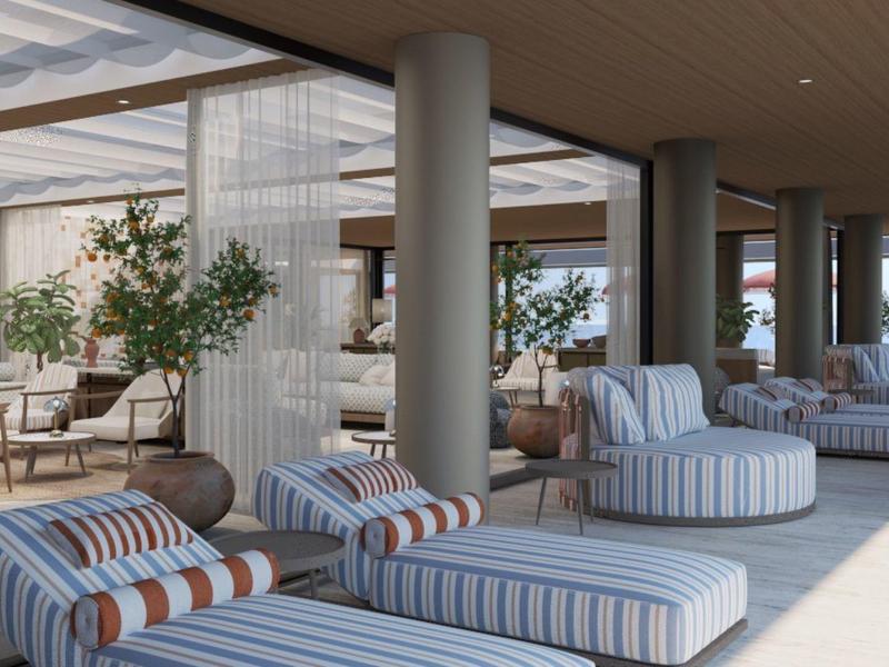 Otevřená lounge s páskovanými pohovkami a sedacími vaky v jasném, moderním designu.