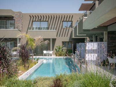 Piscina moderna dell'hotel con sedie a sdraio e piante in un cortile soleggiato
