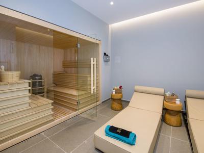 Espace bien-être moderne avec sauna et fauteuils lounge aux tons neutres
