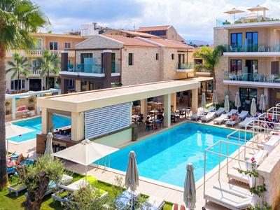 Moderner Hotelpoolbereich mit Liegestühlen, Sonnenschirmen und umliegenden Wohnungen.