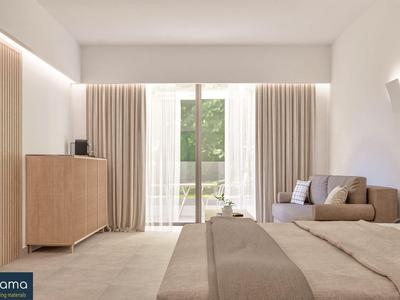 Habitación de hotel luminosa con cama grande, sofá, armario y vista al balcón.