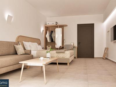 Habitación de hotel luminosa con sofá beige, muebles de madera y diseño minimalista.